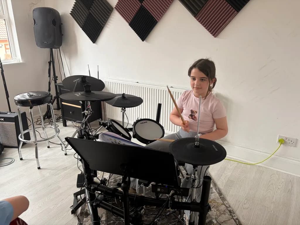 A young student playing the electronic drum kit