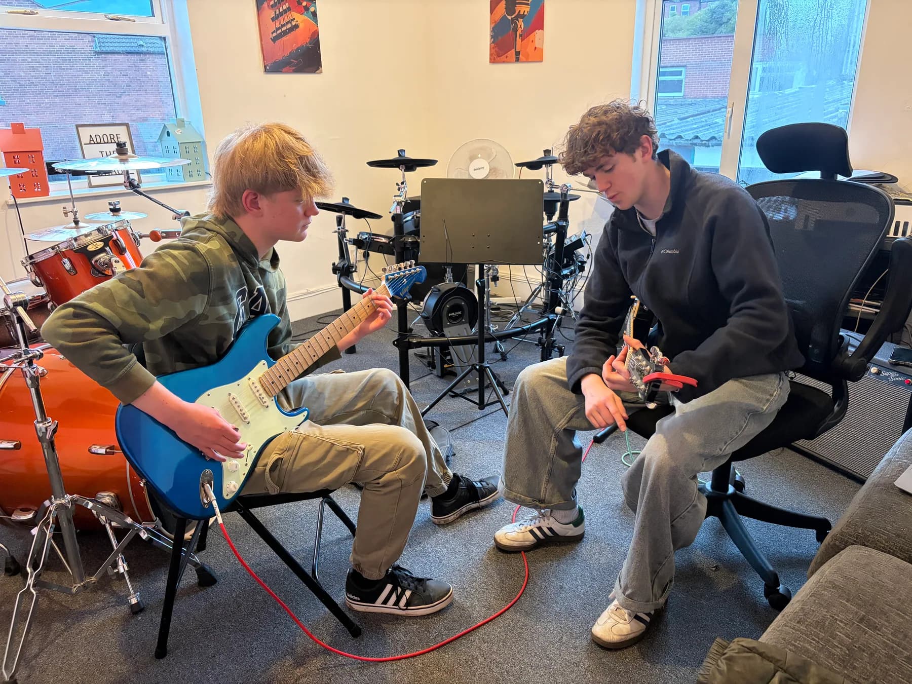 Two guitar students developing a song together