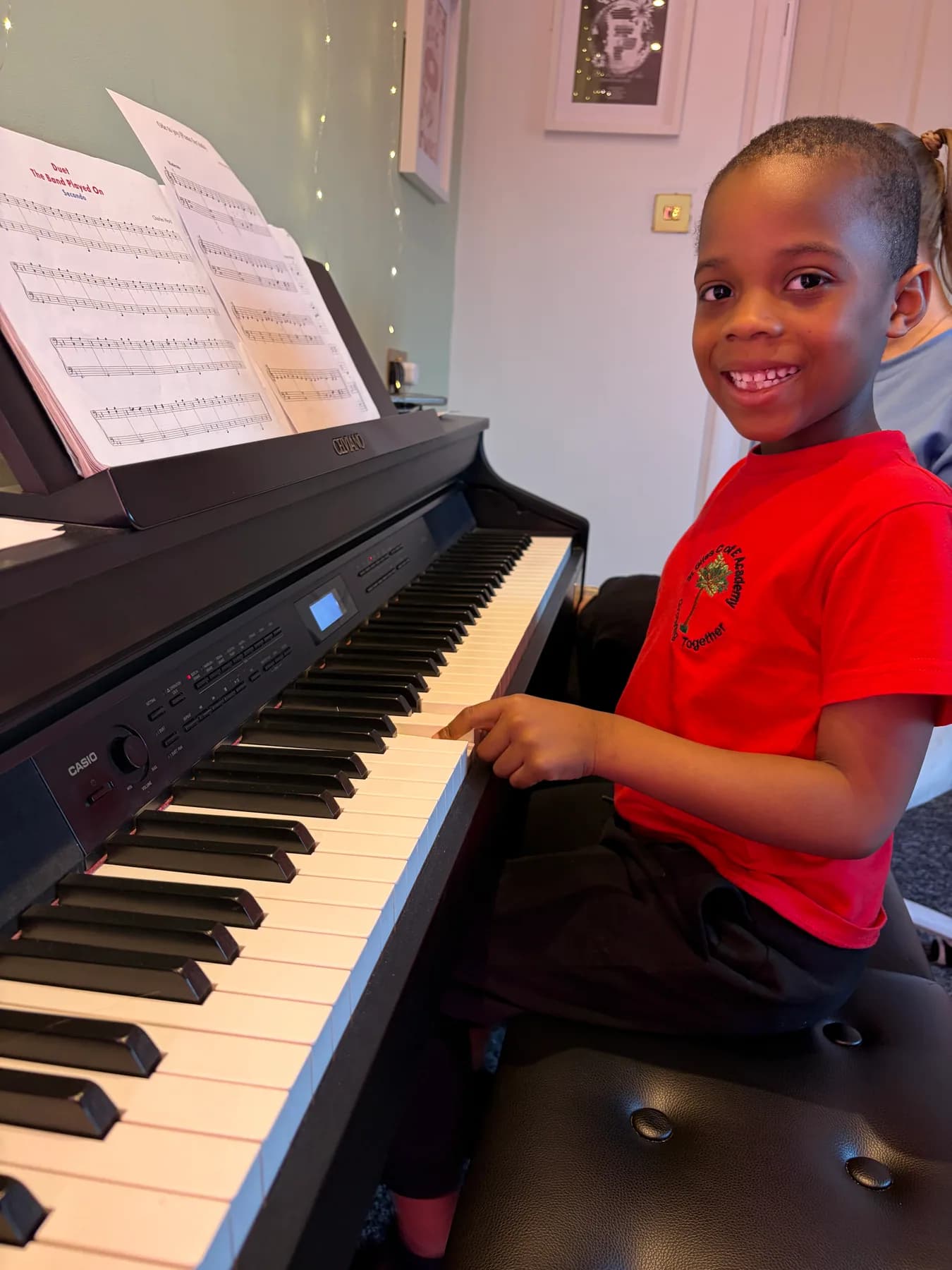 A young piano student smiling during a lesson